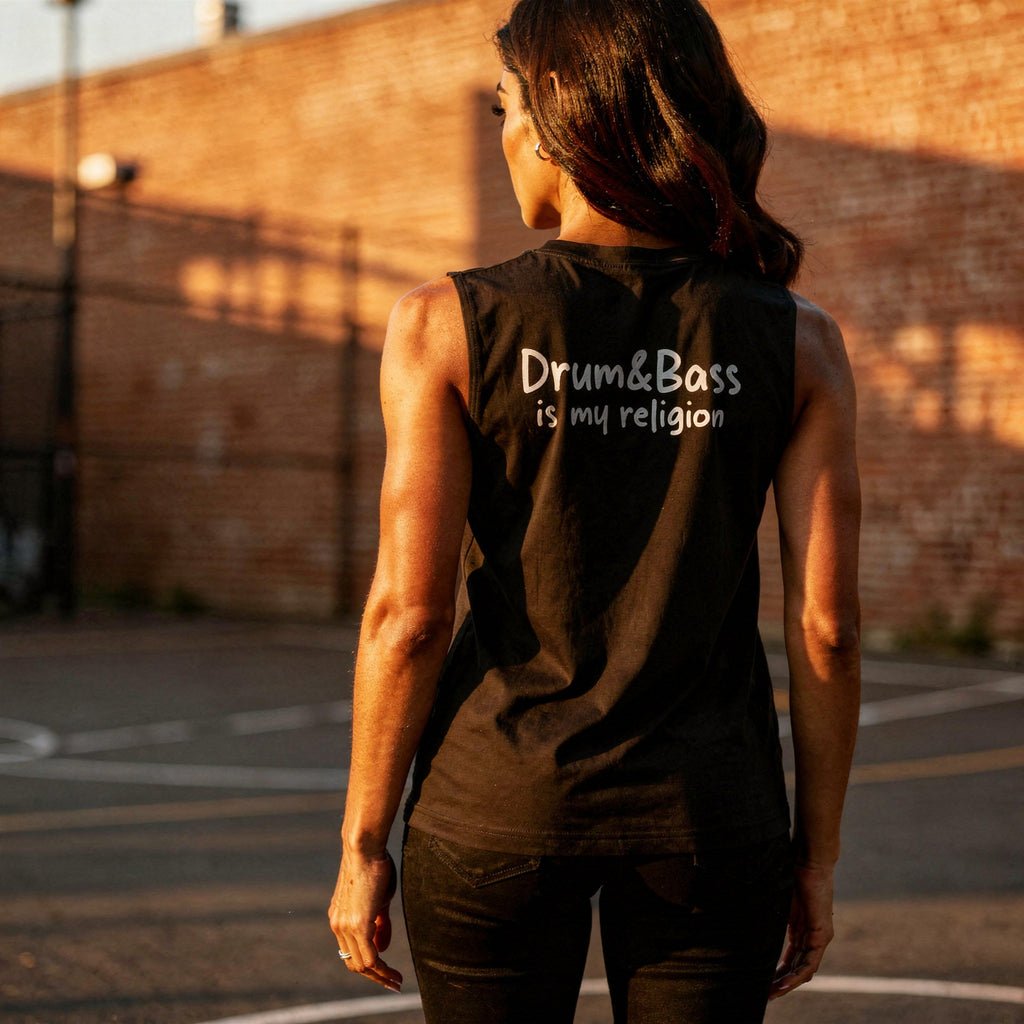 Unisex muscle top with bold geometric Funky Jaysus illustration on the front and “Drum & Bass is my religion” slogan on the back. Lightweight sleeveless streetwear top for DnB fans and festival wear.
