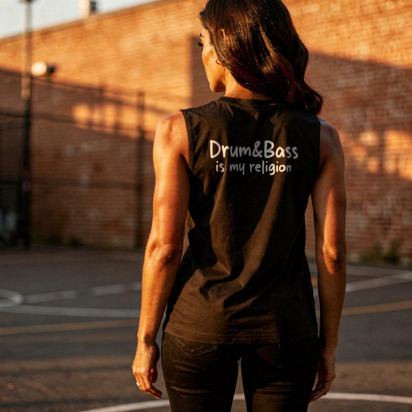 Unisex muscle top with bold geometric Funky Jaysus illustration on the front and “Drum & Bass is my religion” slogan on the back. Lightweight sleeveless streetwear top for DnB fans and festival wear.