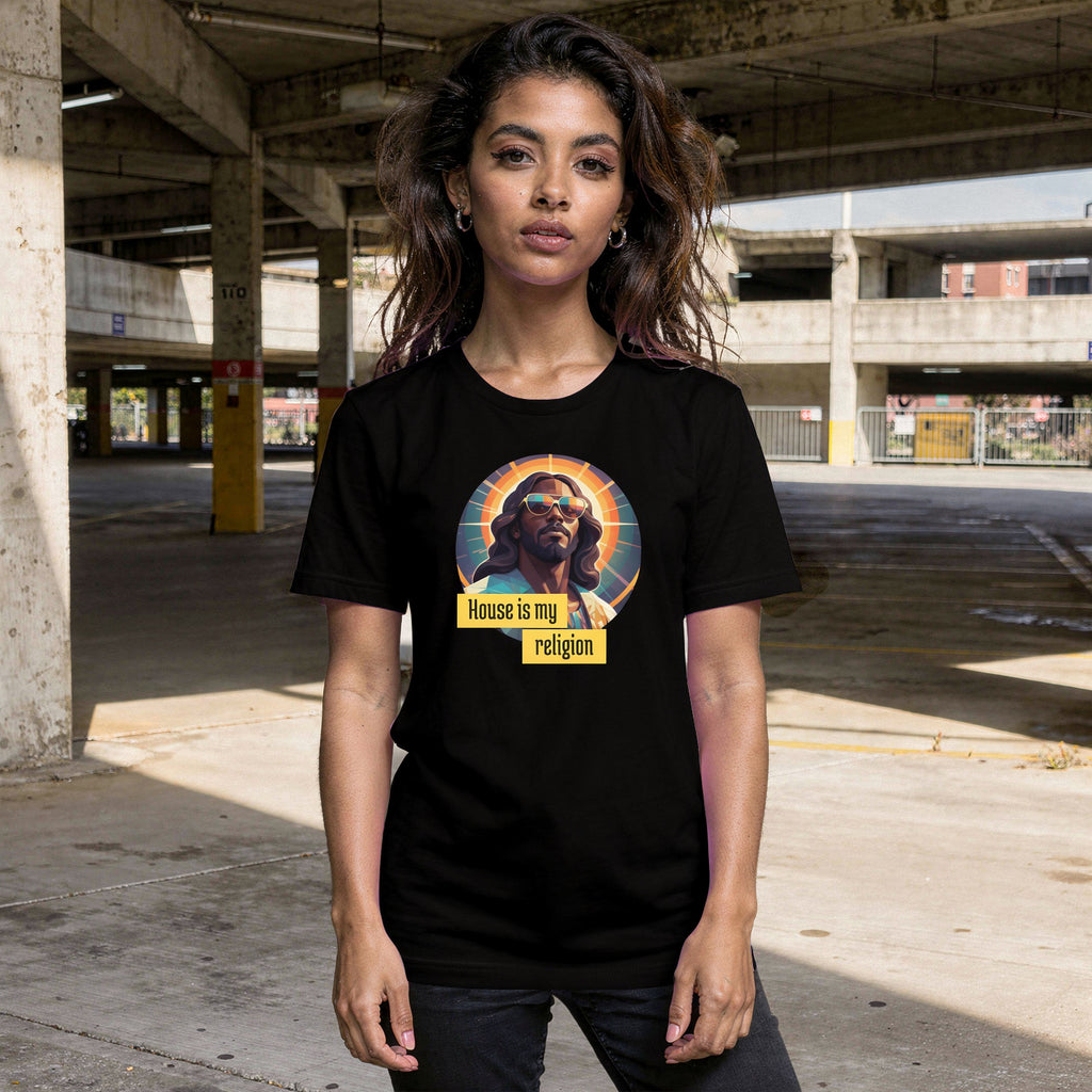 A person wearing a black t-shirt with a graphic design of Funky Jaysus with the wording 'House is my religion' in an empty car park.
