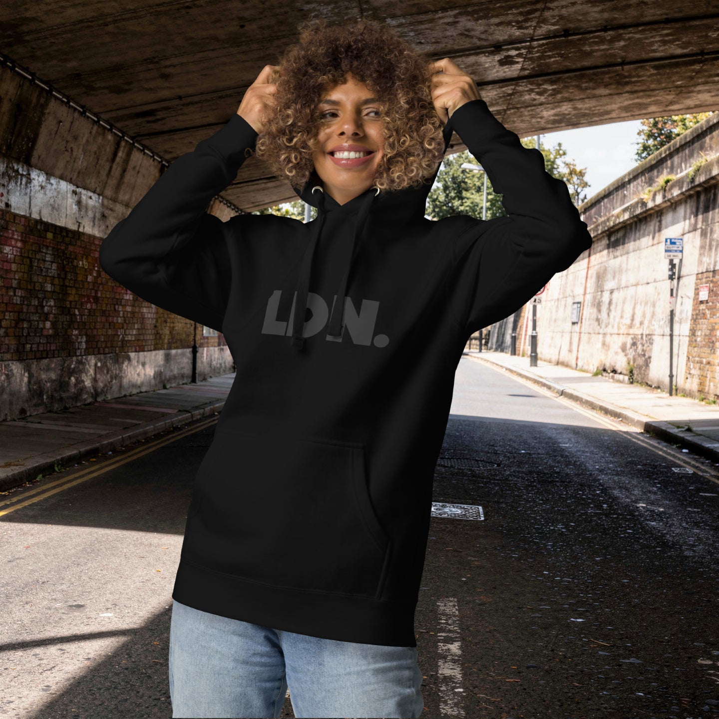 Unisex Hoodie - White hoodie with tonal “LDN.” graphic worn by male model — soft fleece lining, relaxed streetwear silhouette, perfect for layering in cooler seasons.
