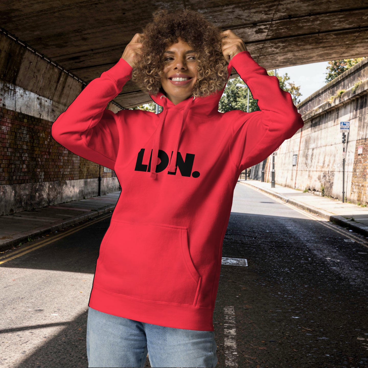 Unisex Hoodie - red hoodie with tonal “LDN.” graphic worn by male model — soft fleece lining, relaxed streetwear silhouette, perfect for layering in cooler seasons.