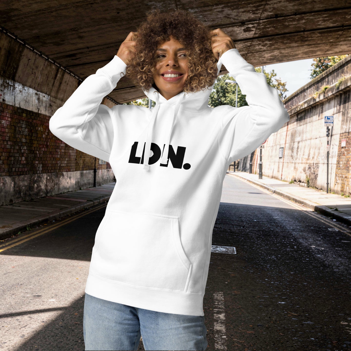 Unisex Hoodie - White hoodie with tonal “LDN.” graphic worn by male model — soft fleece lining, relaxed streetwear silhouette, perfect for layering in cooler seasons.