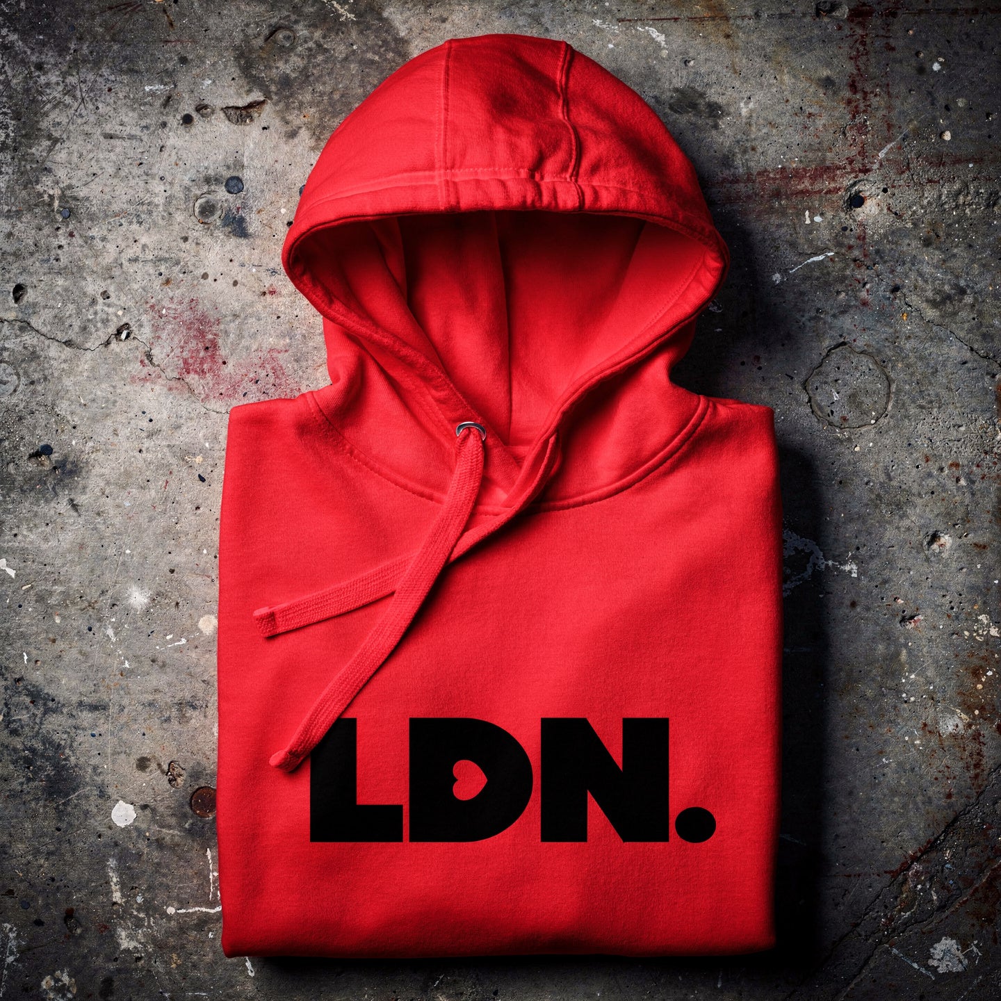Unisex Hoodie - Red hoodie with tonal “LDN.” graphic worn by male model — soft fleece lining, relaxed streetwear silhouette, perfect for layering in cooler seasons.