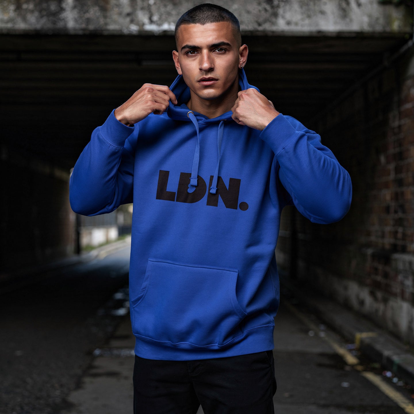 Unisex Hoodie - Blue hoodie with tonal “LDN.” graphic worn by male model — soft fleece lining, relaxed streetwear silhouette, perfect for layering in cooler seasons.
