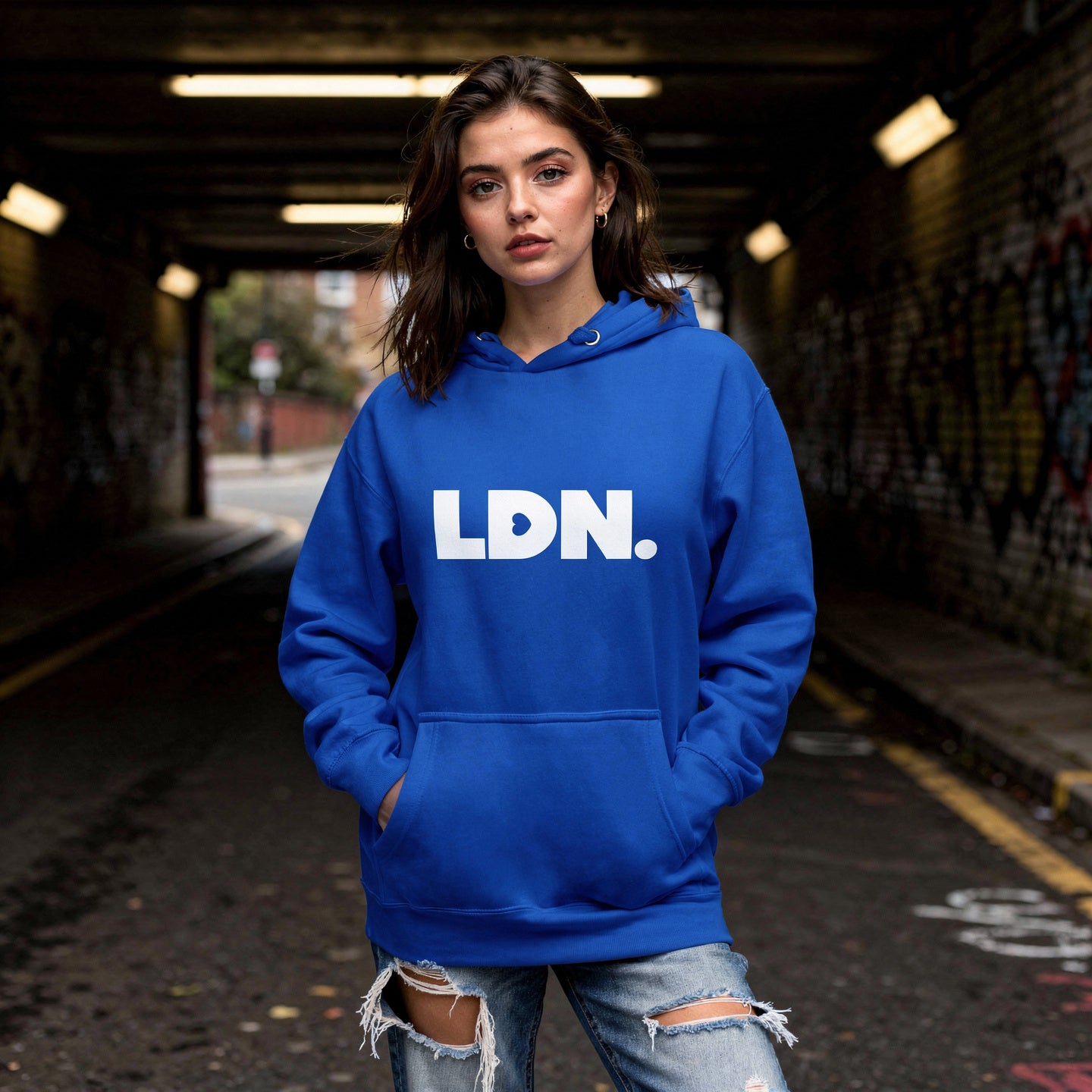Unisex Hoodie - Blue hoodie with white “LDN.” graphic worn by female model — soft fleece lining, relaxed streetwear silhouette, perfect for layering in cooler seasons.