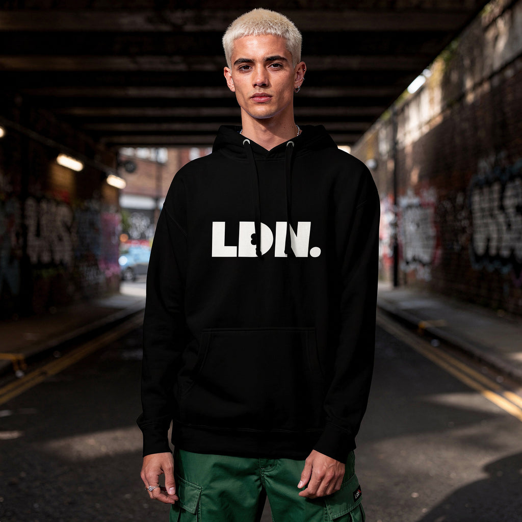 Unisex Hoodie - Black hoodie with white “LDN.” graphic worn by female model — soft fleece lining, relaxed streetwear silhouette, perfect for layering in cooler seasons.