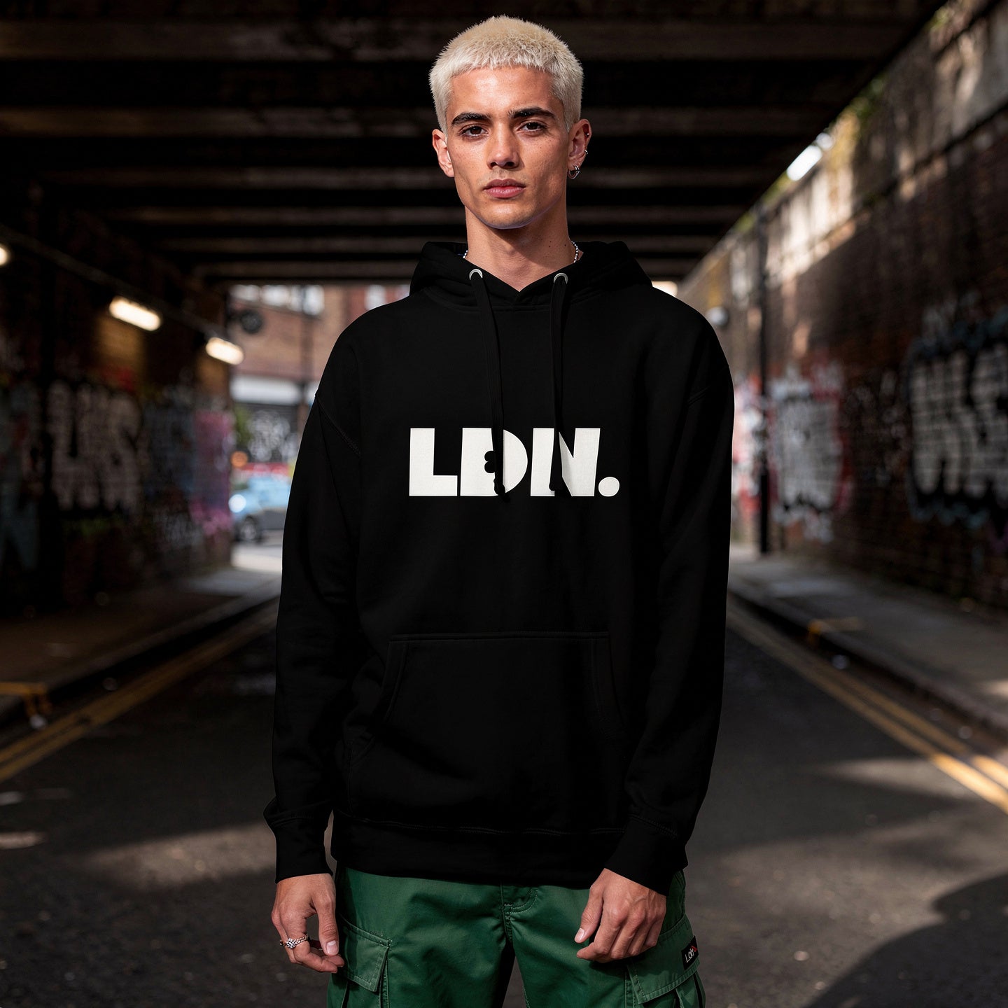Unisex Hoodie - Black hoodie with white “LDN.” graphic worn by female model — soft fleece lining, relaxed streetwear silhouette, perfect for layering in cooler seasons.