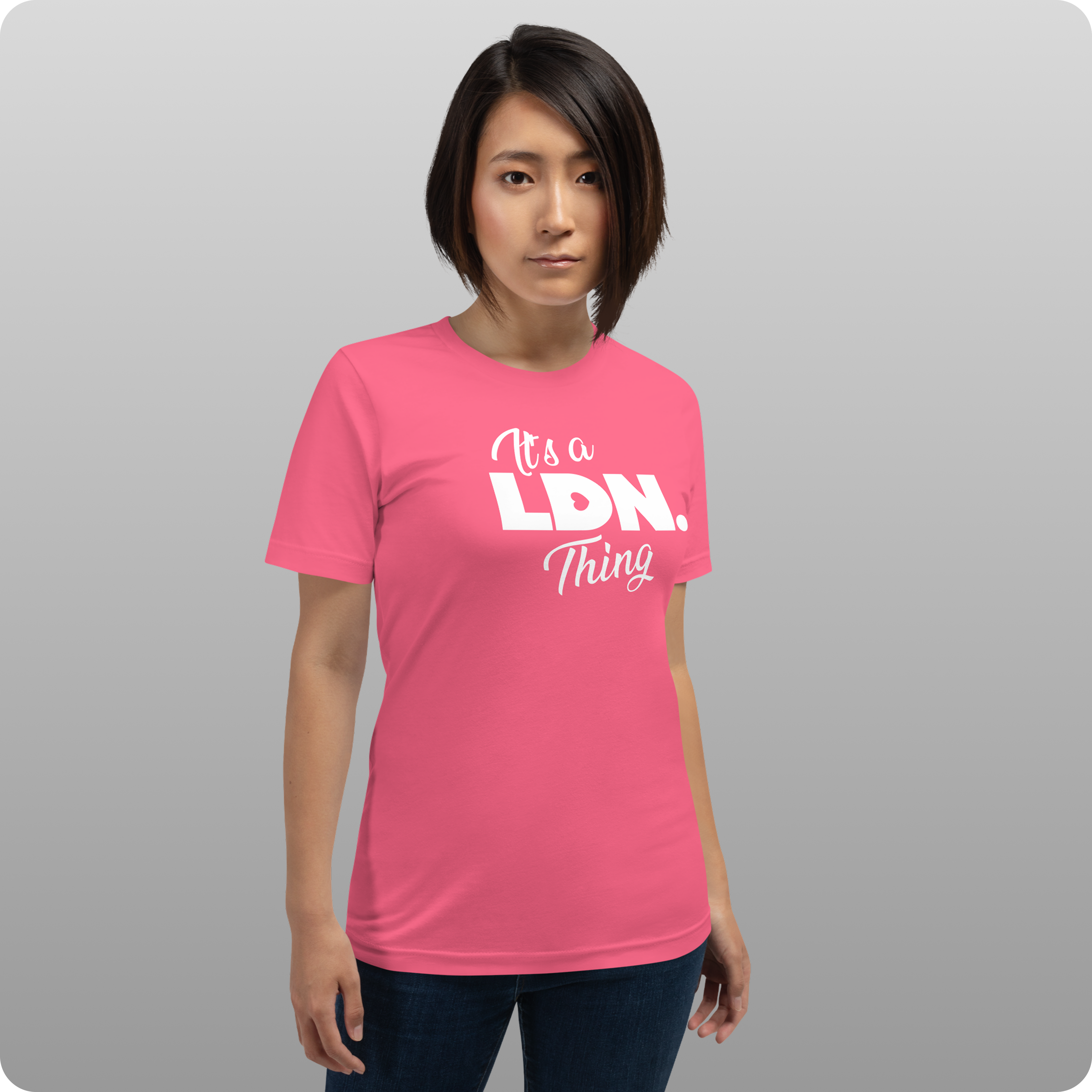 Person wearing a pink t-shirt with text on a gray background