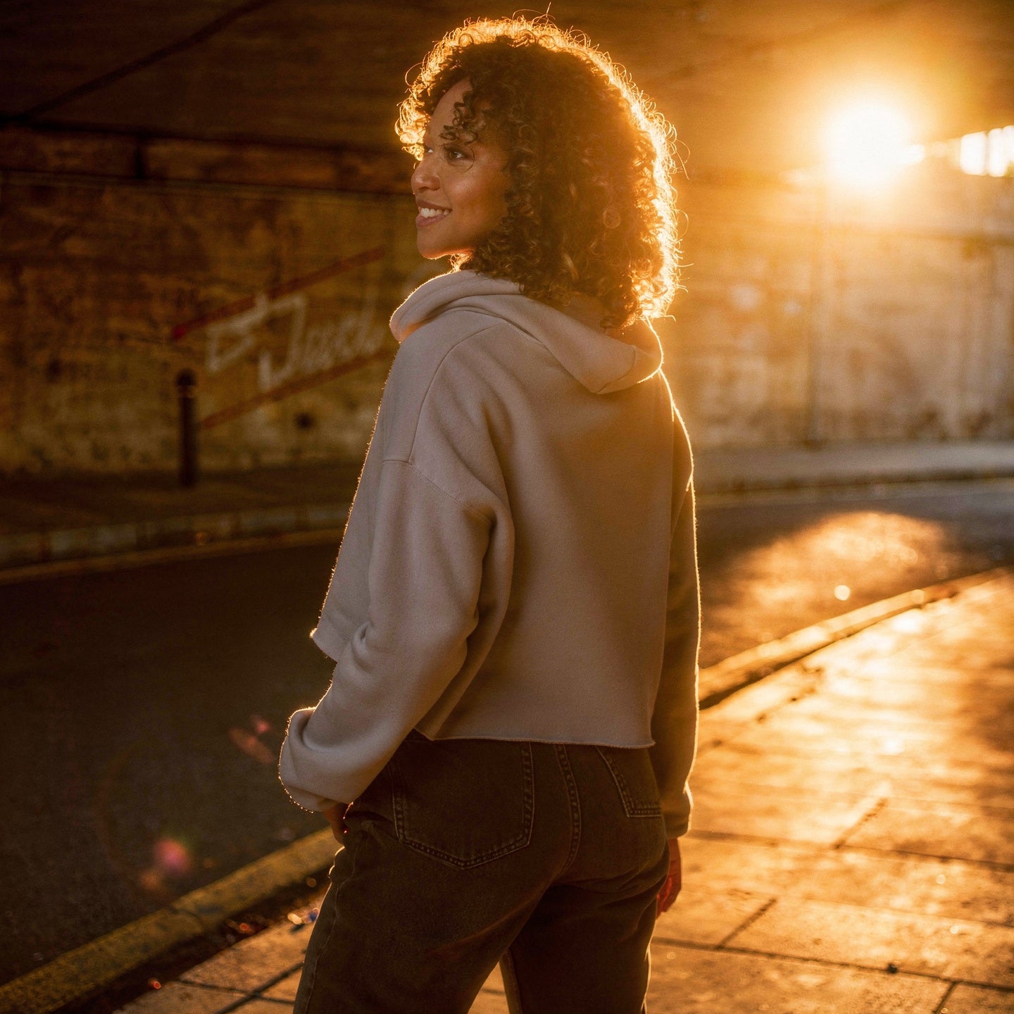 Model wearing a cropped hoodie with tonal “LDN.” graphic. Hoodie features dropped shoulders, raw hem, and dyed-to-match drawstrings. Made from cotton-poly fleece blend for soft comfort and relaxed fit. A minimal, modern streetwear piece.