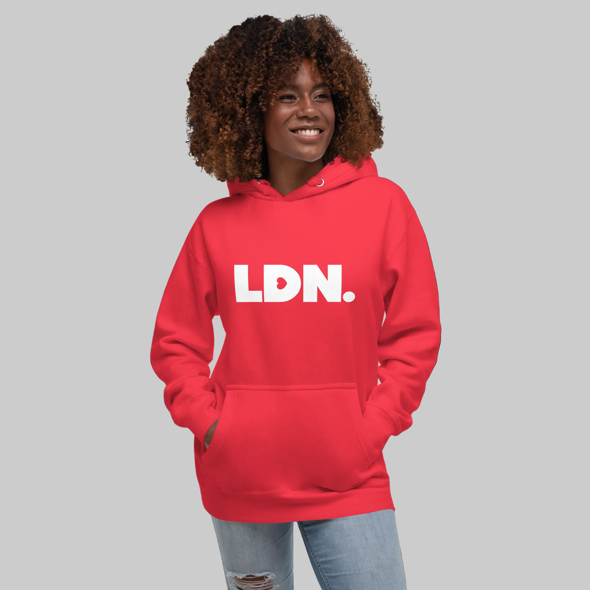 Unisex Hoodie - Red hoodie with tonal “LDN.” graphic worn by female model — soft fleece lining, relaxed streetwear silhouette, perfect for layering in cooler seasons.