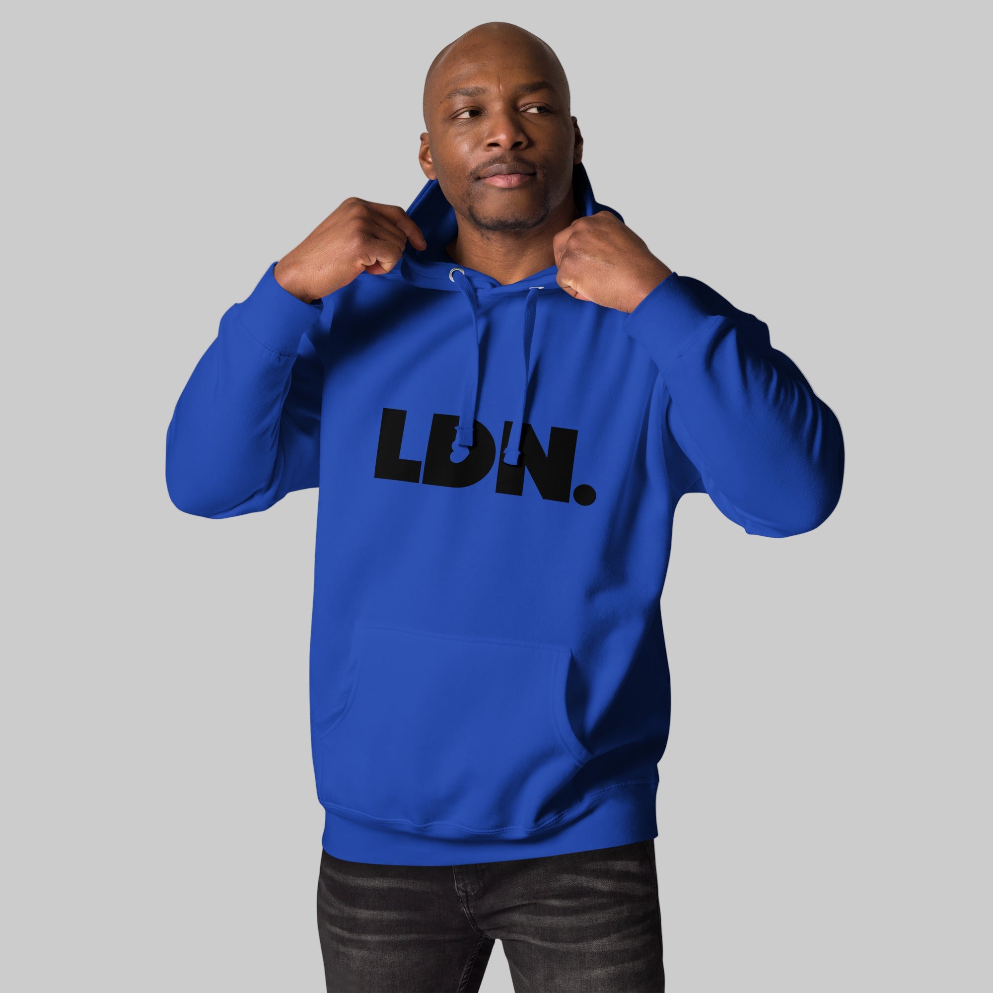 Unisex Hoodie - Black hoodie with tonal “LDN.” graphic worn by male model — soft fleece lining, relaxed streetwear silhouette, perfect for layering in cooler seasons.