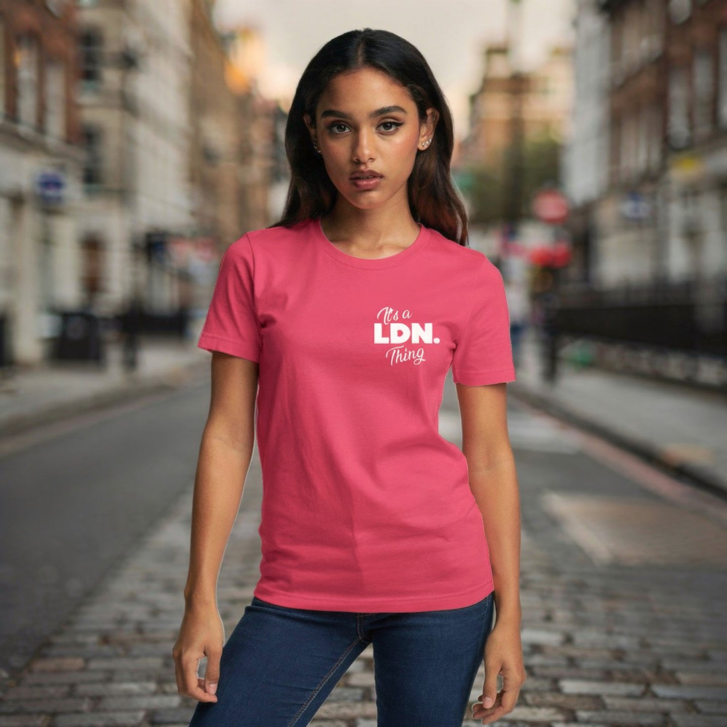 Woman wearing a pink t-shirt with 'It's a LDN Thing' text on a city street.