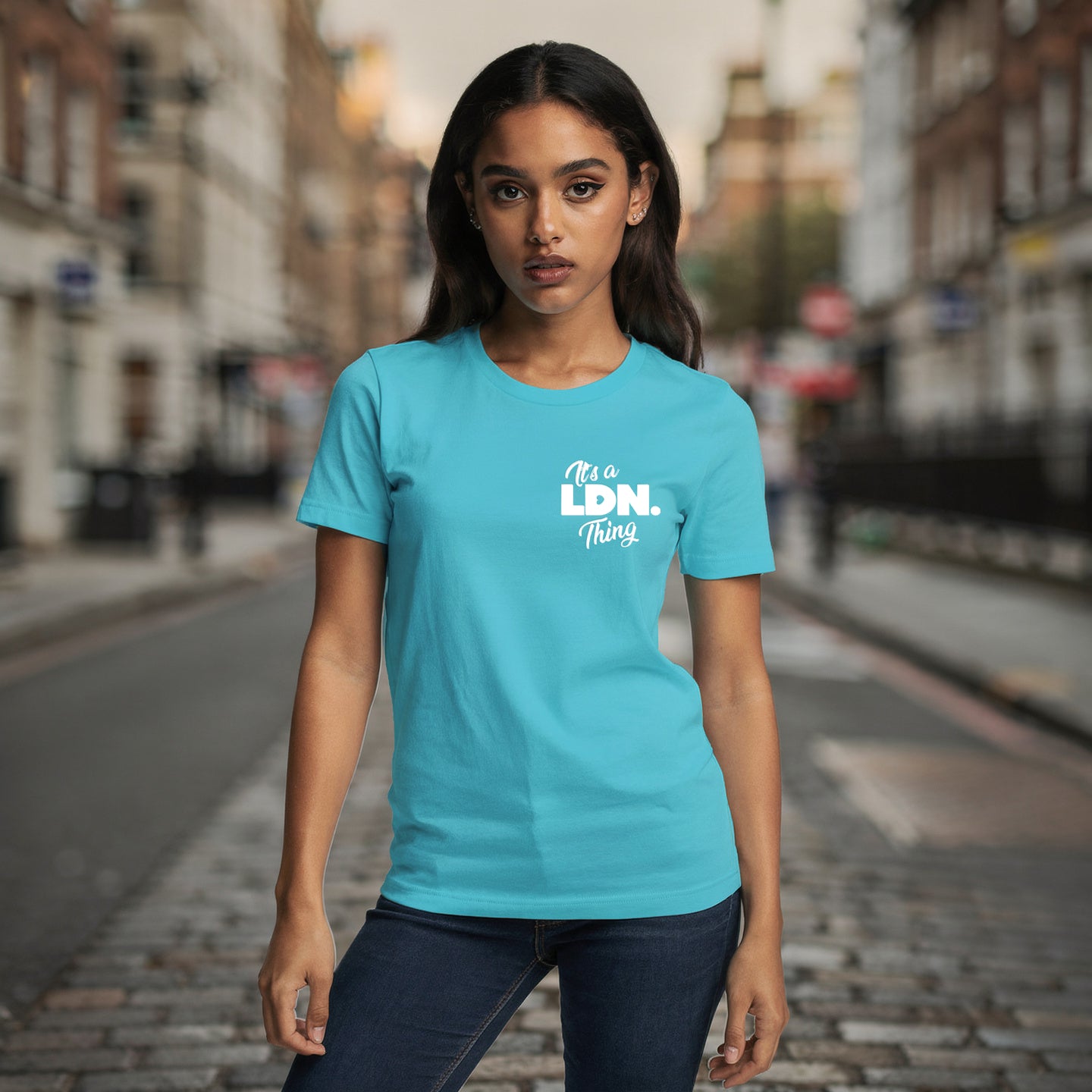 Woman wearing a turquoise t-shirt with 'It's a Ldn Thing' text on a city street.
