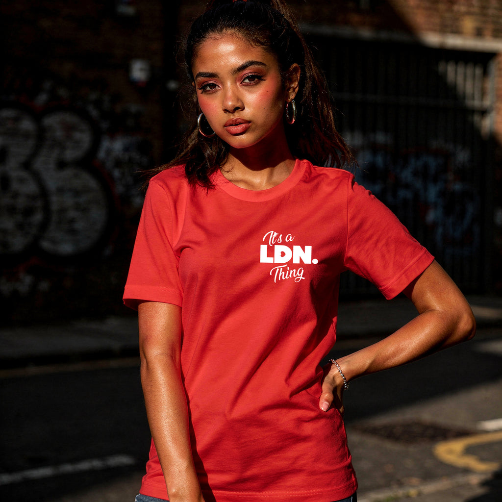 Person wearing a red t-shirt with 'It's a LDN Thing' text, standing against a dark background.