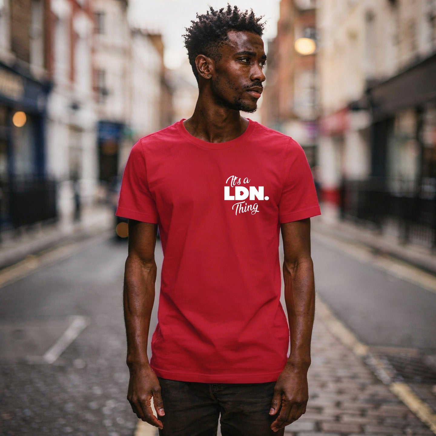 Man wearing a red t-shirt with 'It's a LDN Thing' text on a street background