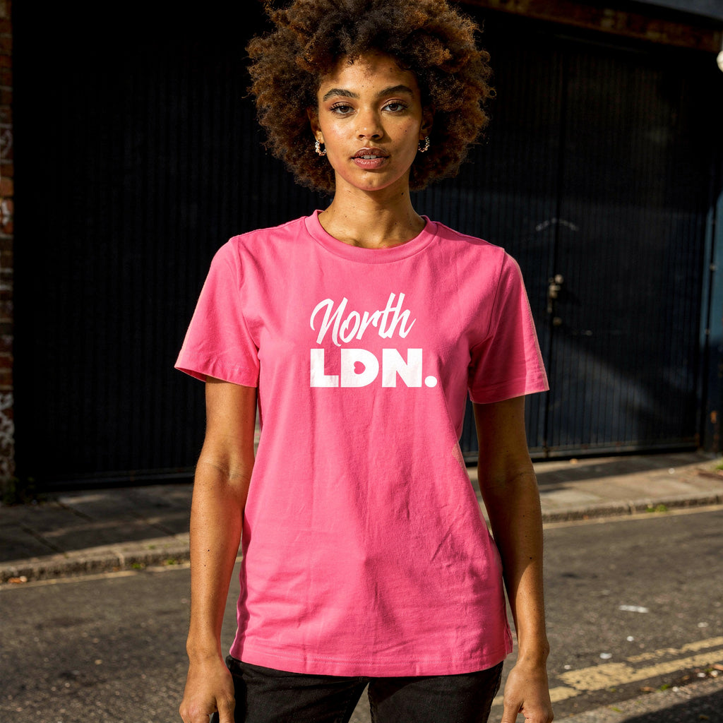 Person wearing a pink 'North LDN' t-shirt standing on a street.