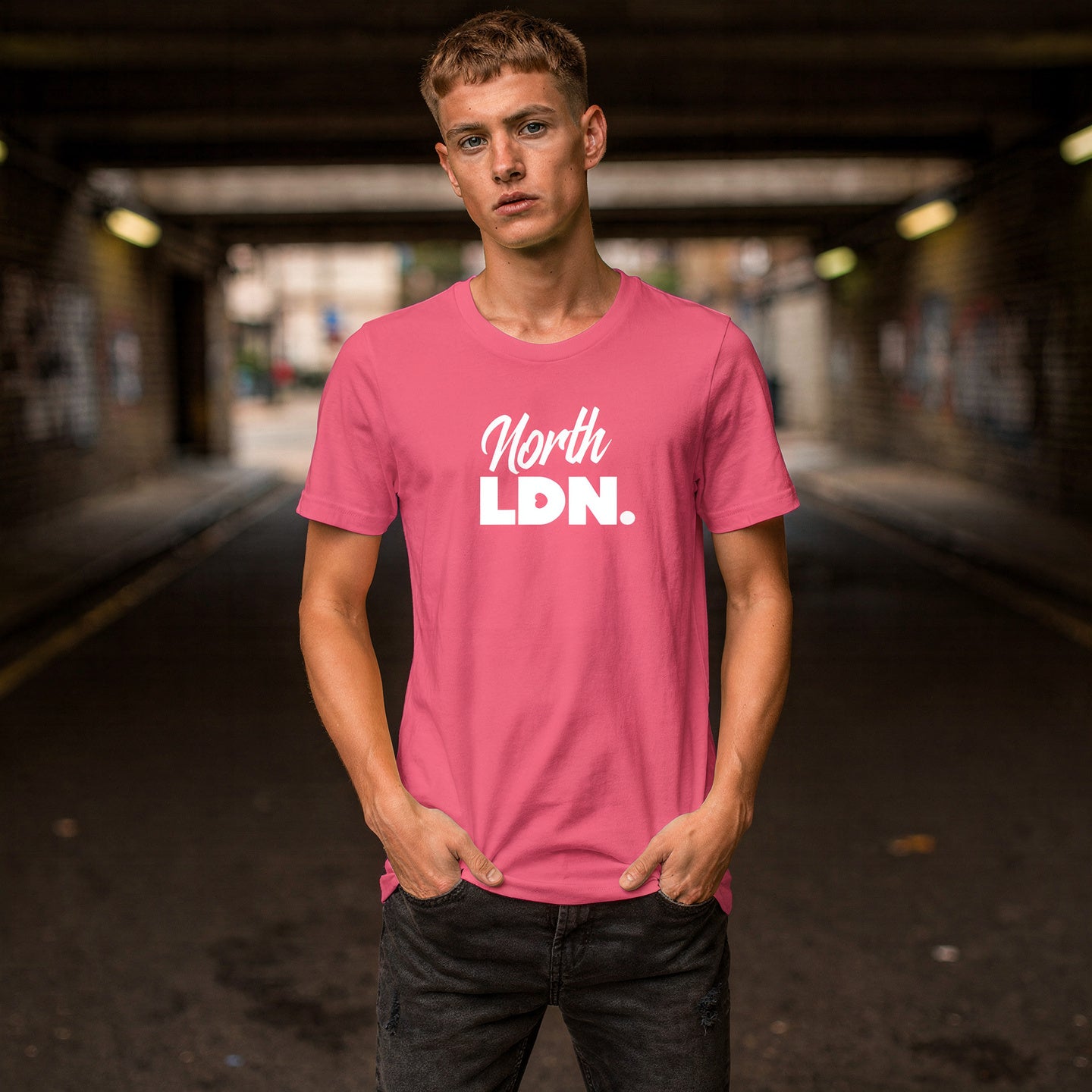Person wearing a pink t-shirt with 'North LDN.' text in an urban setting