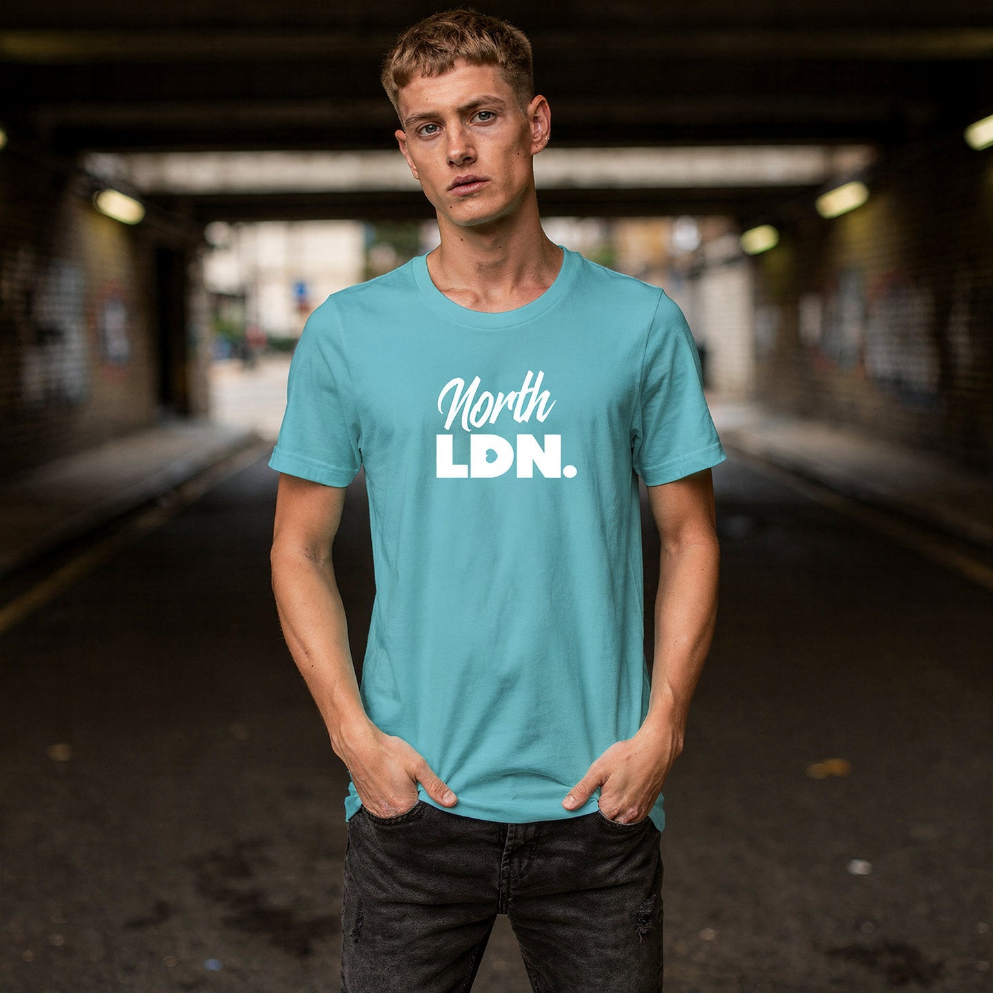 Man wearing a turquoise t-shirt with 'North Ldn.' text in an urban setting