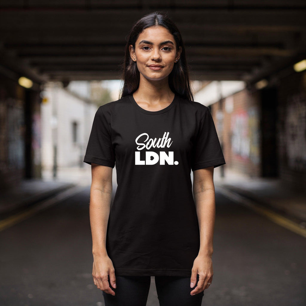 Woman is wearing a black t-shirt with 'South LDN. ' text in an urban setting