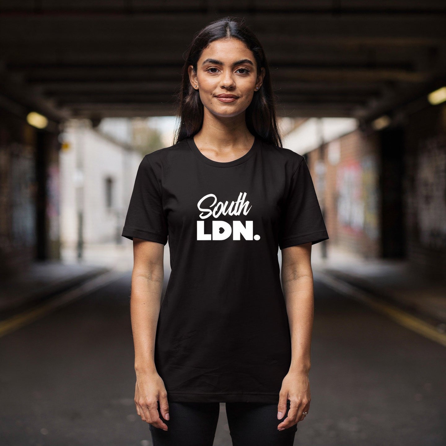 Woman is wearing a black t-shirt with 'South LDN. ' text in an urban setting