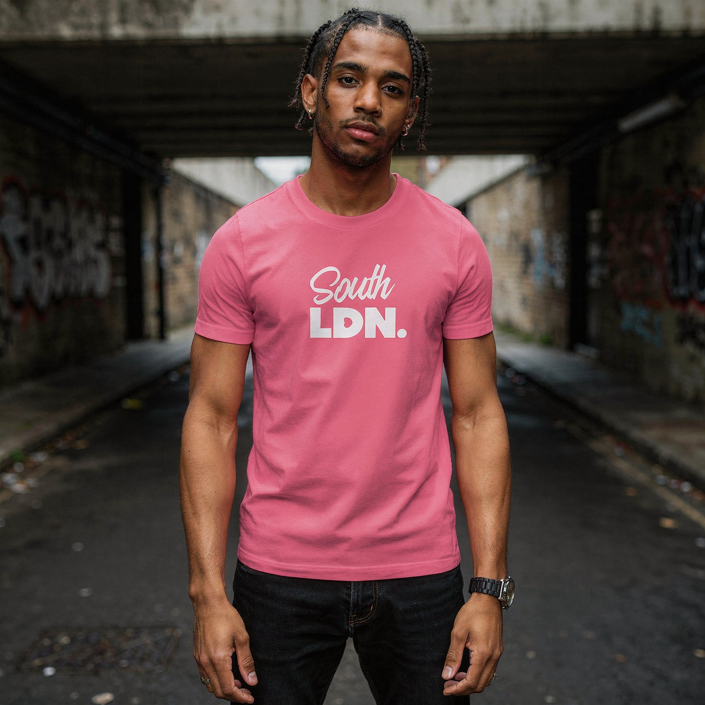 Man wearing a pink t-shirt with 'South LDN' text in an urban setting