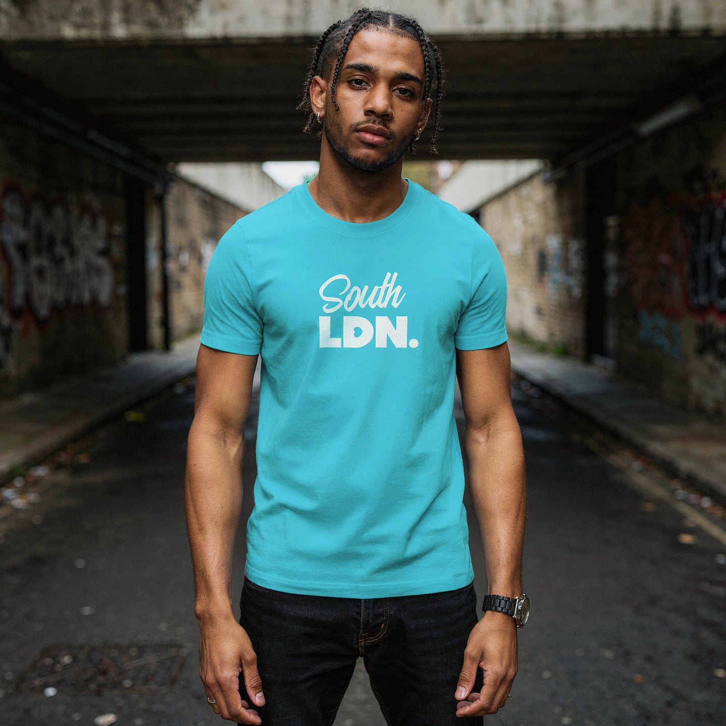 Man wearing a turquoise t-shirt with 'South LDN' text in an urban setting