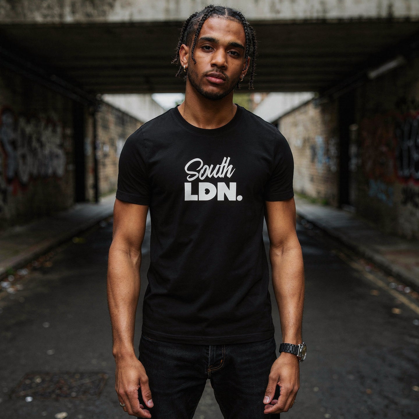 Man wearing a black t-shirt with 'South LDN.' text in an urban setting