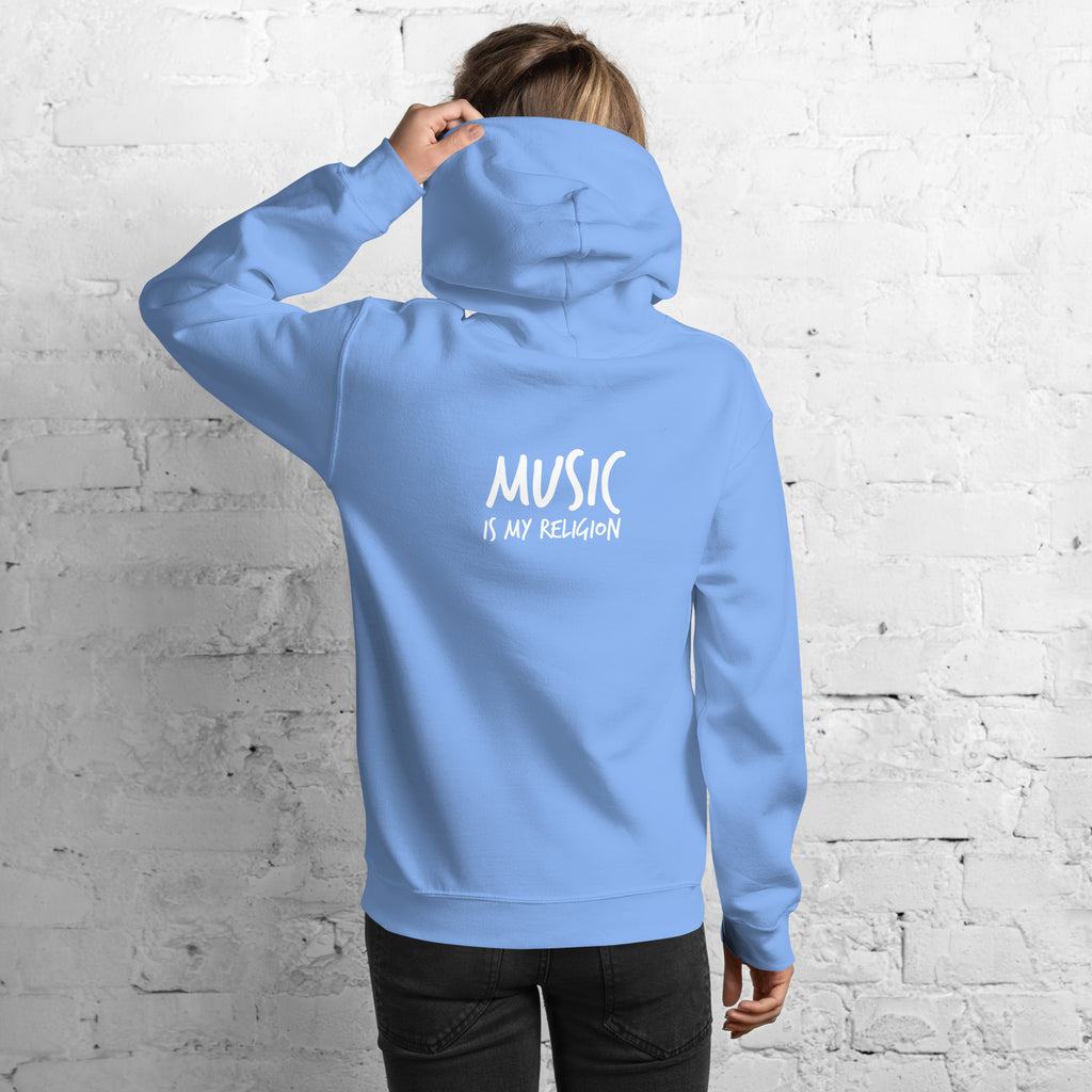 Person wearing a blue hoodie with 'Music is my Religion' text on the back against a white brick wall.