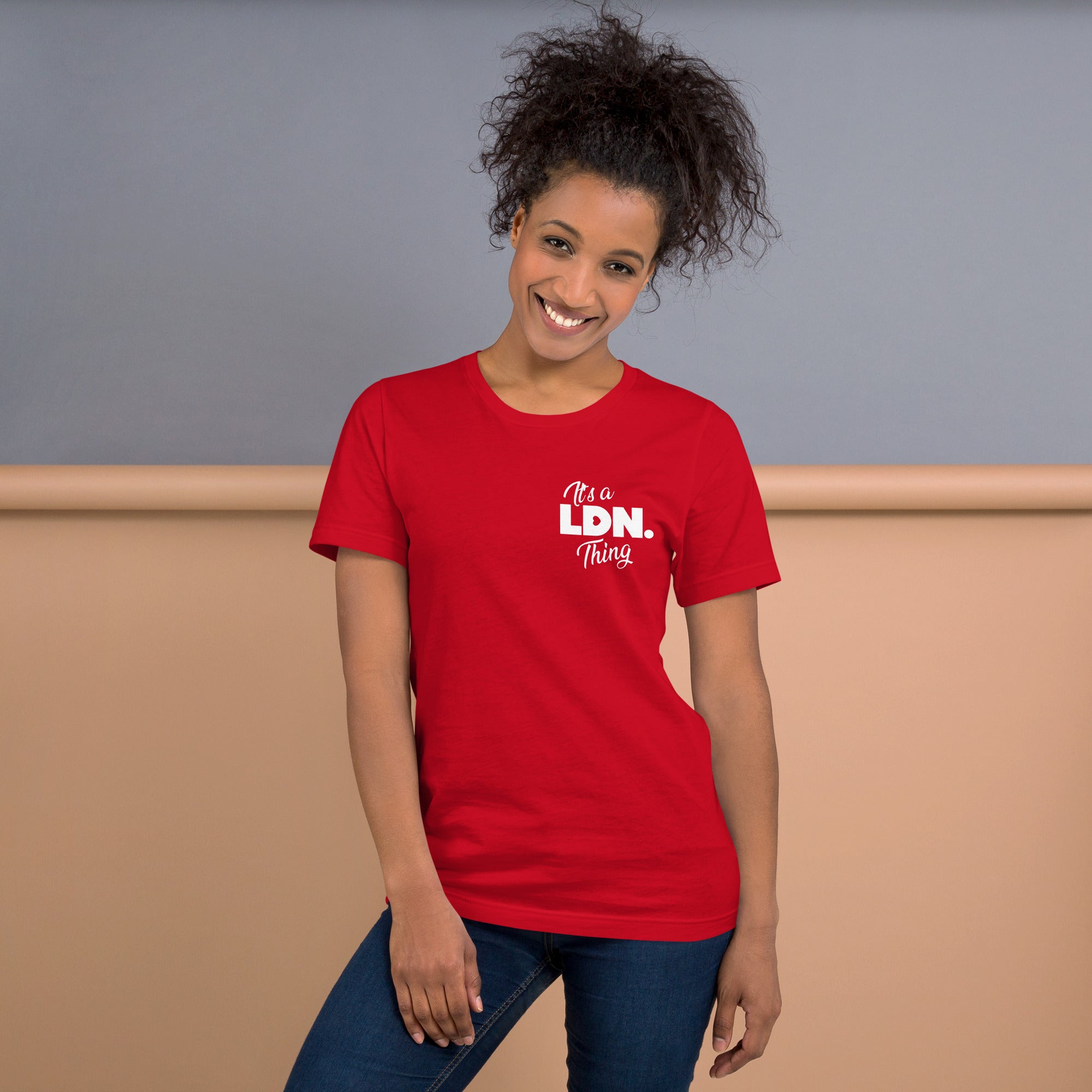 Woman wearing a red t-shirt with 'It's a LDN Thing' text, standing against a plain background
