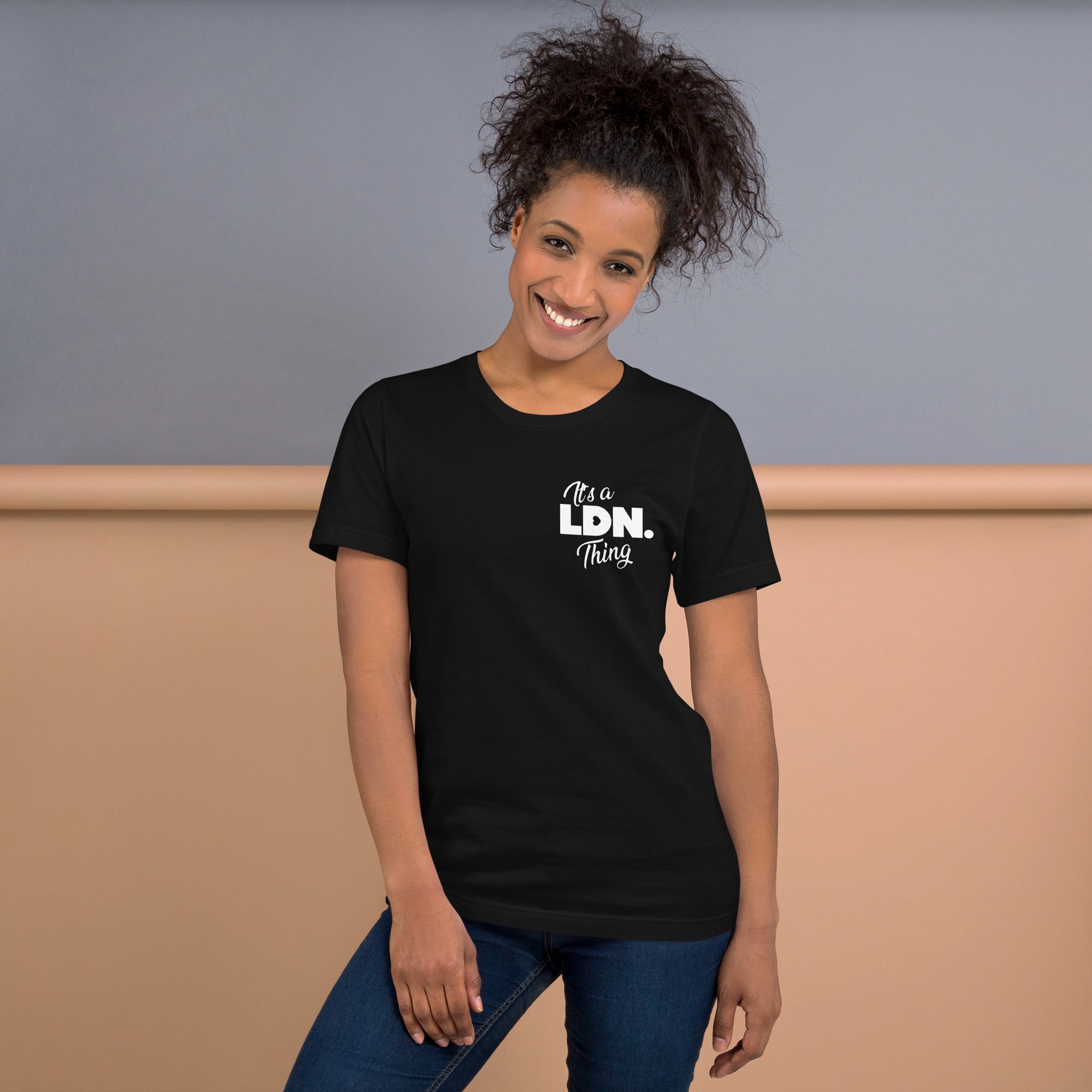 Woman wearing a black t-shirt with 'It's a LDN Thing' text, standing against a plain background