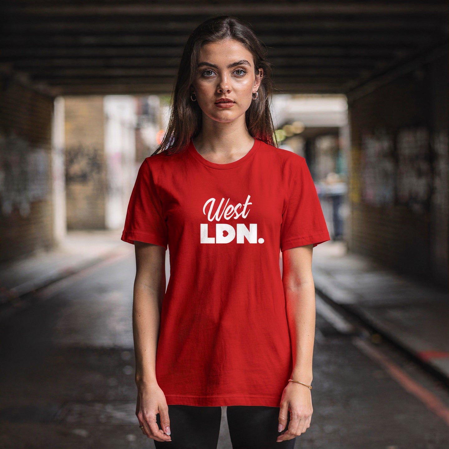 Model wearing a t-shirt with 'West LDN' text, standing in an urban London setting.