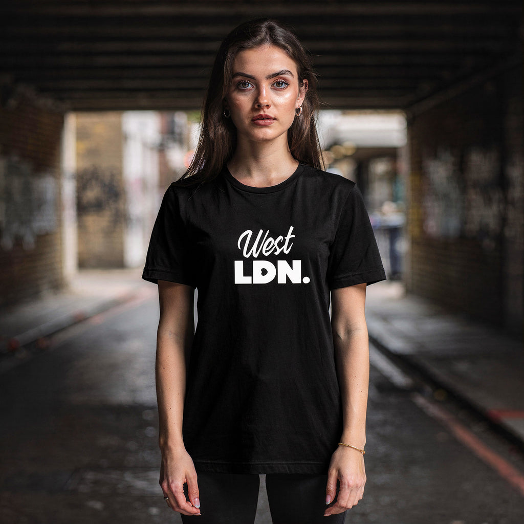 Model wearing a t-shirt with 'West LDN' text, standing in an urban London setting.