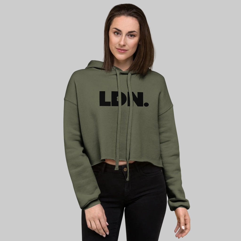 Model wearing a cropped hoodie with tonal “LDN.” graphic. Hoodie features dropped shoulders, raw hem, and dyed-to-match drawstrings. Made from cotton-poly fleece blend for soft comfort and relaxed fit. A minimal, modern streetwear piece.