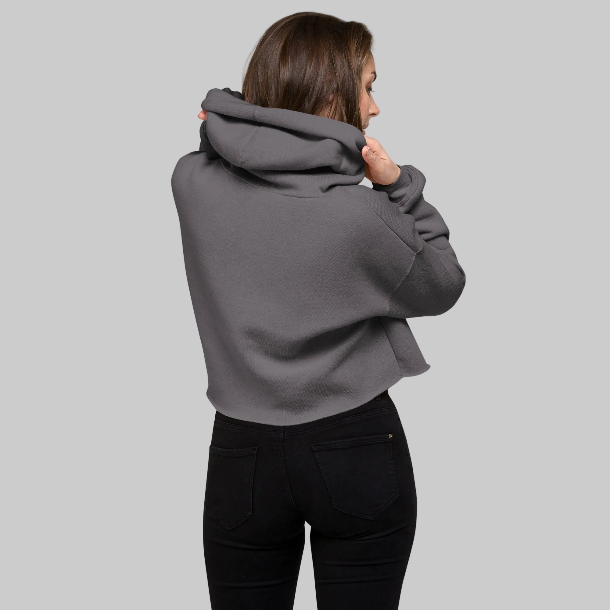 Model wearing a cropped hoodie with tonal “LDN.” graphic. Hoodie features dropped shoulders, raw hem, and dyed-to-match drawstrings. Made from cotton-poly fleece blend for soft comfort and relaxed fit. A minimal, modern streetwear piece.
